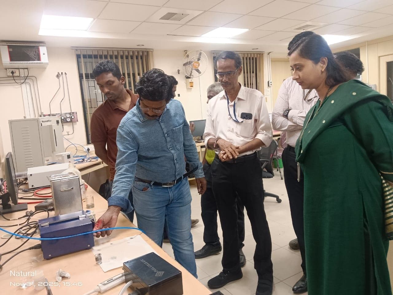 Participants gathered around a fuel cell test station